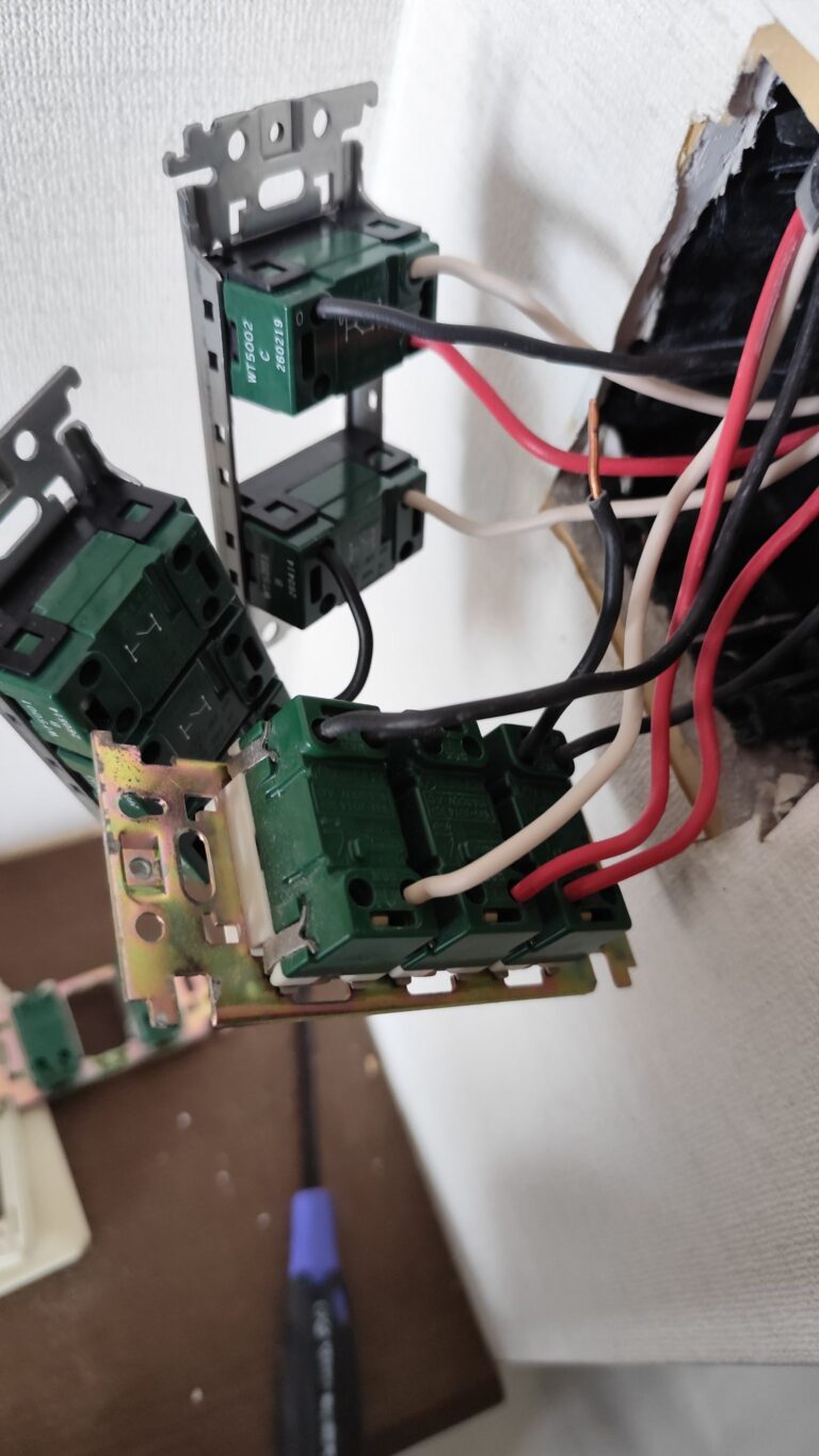 壁のスイッチボックスでスイッチ器具を結線している様子